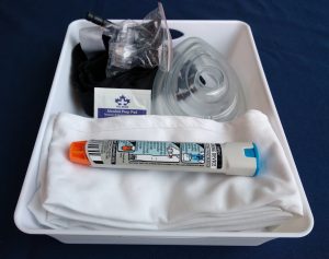White plastic tray containing first aid supplies for use during a first aid class.