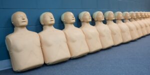 CPR manikins lined up against a blue wall